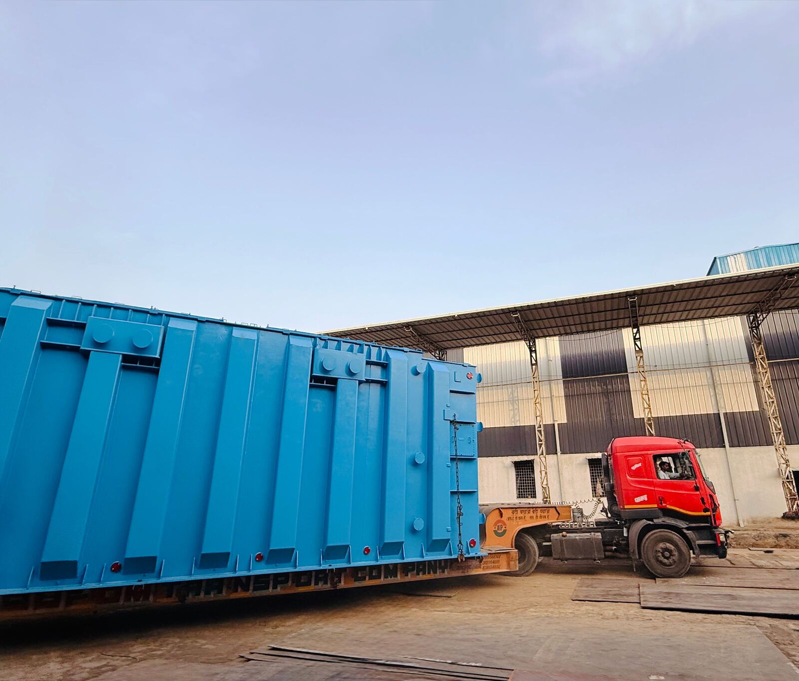Blue painted fabricated enclosure loaded on a trailer for delivery