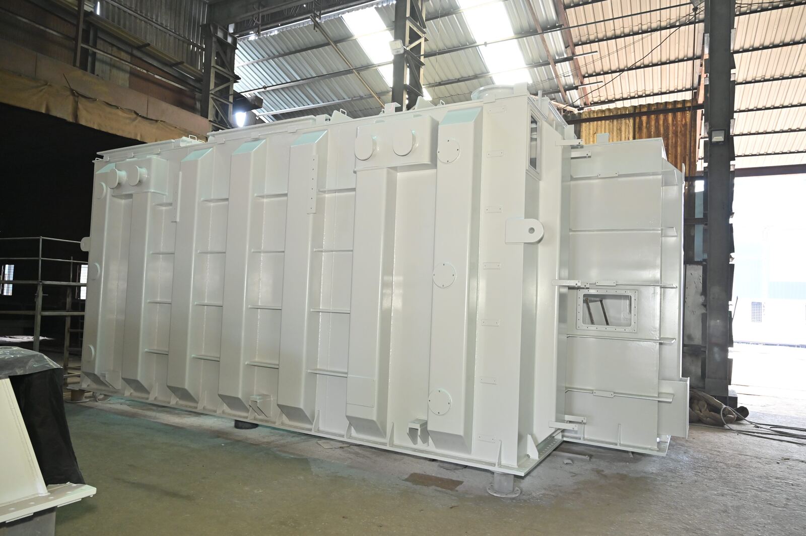 Large white painted fabricated tank with stiffened side panels inside the workshop